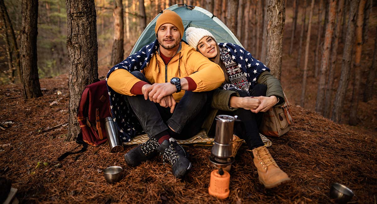 couple in front of tent cuddling for regenerative camping